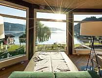 Modernes Spa mit Liegen und großen Fenstern zum See