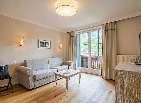 Helles Wohnzimmer mit Sofa, Couchtisch und Blick auf den Balkon